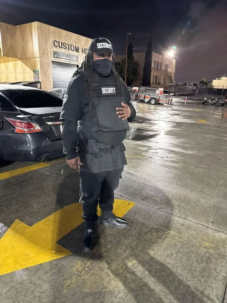 Security guard in tactical vest standing in a parking lot at night